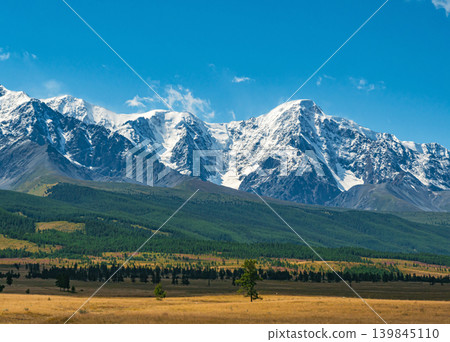 Grand Altai mountains display their snow-covered peaks. Lush green forest covers the foothills below Grand Altai mountains display their snow-covered peaks. Lush green forest covers the foothills below 139845110