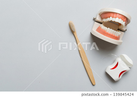 Closeup model of a human jaw with white teeth and Toothbrush. Dentistry conceptual photo. Prosthetic dentistry. False teet top view with copy space Closeup model of a human jaw with white teeth and Toothbrush. Dentistry conceptual photo. Prosthetic dentistry. False teet top view with copy space 139845424