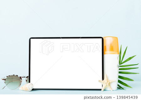 Flat lay composition with tablet and beach accessories on colored background. Tablet computer with blank screen mock up with copy space Flat lay composition with tablet and beach accessories on colored background. Tablet computer with blank screen mock up with copy space 139845439