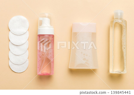 Micellar cleansing water and discs to remove cosmetics and cleanse the skin on colored background. Copy space top view Micellar cleansing water and discs to remove cosmetics and cleanse the skin on colored background. Copy space top view 139845441