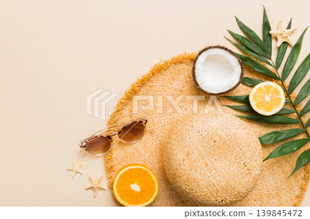 Top view of various seashells placed near colorful fruit and stylish summer accessories on table background. Summer concept. Flat lay. Top view with copy space for text Top view of various seashells placed near colorful fruit and stylish summer accessories on table background. Summer concept. Flat lay. Top view with copy space for text 139845472