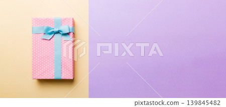 holiday handmade paper present tied blue ribbon bow top view with copy space. Flat lay holiday background. Birthday or christmas present. Christmas gift box concept with copy space holiday handmade paper present tied blue ribbon bow top view with copy space. Flat lay holiday background. Birthday or christmas present. Christmas gift box concept with copy space 139845482