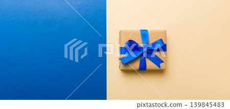 holiday handmade paper present tied blue ribbon bow top view with copy space. Flat lay holiday background. Birthday or christmas present. Christmas gift box concept with copy space 139845483