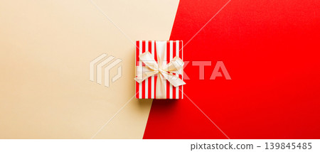 holiday paper present tied yellow ribbon bow top view with copy space. Flat lay holiday background. Birthday or christmas present. Christmas gift box concept with copy space holiday paper present tied yellow ribbon bow top view with copy space. Flat lay holiday background. Birthday or christmas present. Christmas gift box concept with copy space 139845485