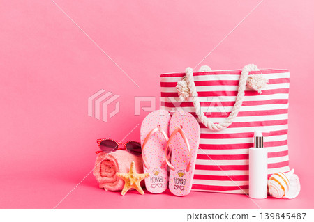 Stylish bag with beach accessories . Summer holiday concept. Top view of beach bag with sunscreen cream with space for text Stylish bag with beach accessories . Summer holiday concept. Top view of beach bag with sunscreen cream with space for text 139845487