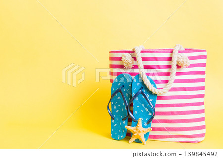 Stylish bag with beach accessories . Summer holiday concept. beach bag with straw hat with space for text Stylish bag with beach accessories . Summer holiday concept. beach bag with straw hat with space for text 139845492