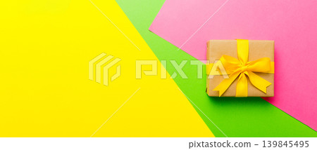 holiday paper present tied yellow ribbon bow top view with copy space. Flat lay holiday background. Birthday or christmas present. Christmas gift box concept with copy space holiday paper present tied yellow ribbon bow top view with copy space. Flat lay holiday background. Birthday or christmas present. Christmas gift box concept with copy space 139845495