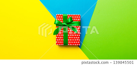 holiday paper present tied yellow ribbon bow top view with copy space. Flat lay holiday background. Birthday or christmas red present. Christmas gift box concept with copy space 139845501