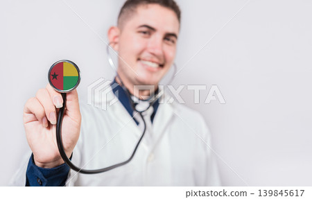 Doctor showing stethoscope with Guinea Bissau flag. Guinea Bissau national healthcare concept Doctor showing stethoscope with Guinea Bissau flag. Guinea Bissau national healthcare concept 139845617
