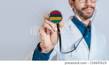 Doctor holding stethoscope with Mauritius flag. Mauritius health and care concept, Mauritius flag on stethoscope Doctor holding stethoscope with Mauritius flag. Mauritius health and care concept, Mauritius flag on stethoscope 139845629