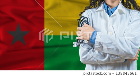 Healthcare professional with Guinea Bissau flag background. Professional doctor holding stethoscope on Guinea Bissau flag background Healthcare professional with Guinea Bissau flag background. Professional doctor holding stethoscope on Guinea Bissau flag background 139845661