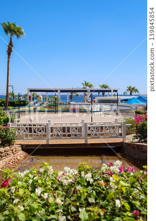 A neat pond with a bridge overlooking the sea A neat pond with a bridge overlooking the sea 139845854