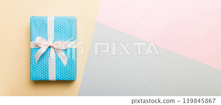 holiday handmade paper present tied white ribbon bow top view with copy space. Flat lay holiday background. Birthday or christmas present. Christmas gift box concept with copy space holiday handmade paper present tied white ribbon bow top view with copy space. Flat lay holiday background. Birthday or christmas present. Christmas gift box concept with copy space 139845867