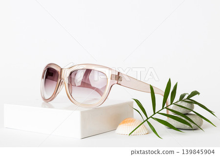 sunglasses with seashell lying on table background. Sunglasses on summer background. Top view flat lay with copy space for text 139845904