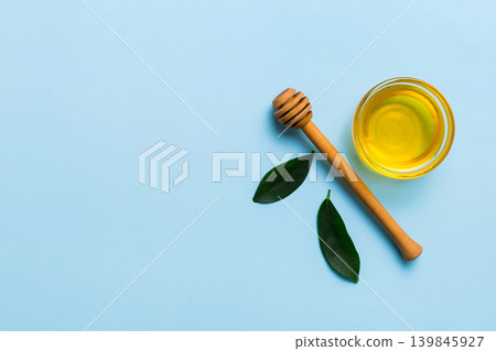 Honey jar with wooden honey dipper on white background top view with copy space. Delicious honey bottle Honey jar with wooden honey dipper on white background top view with copy space. Delicious honey bottle 139845927
