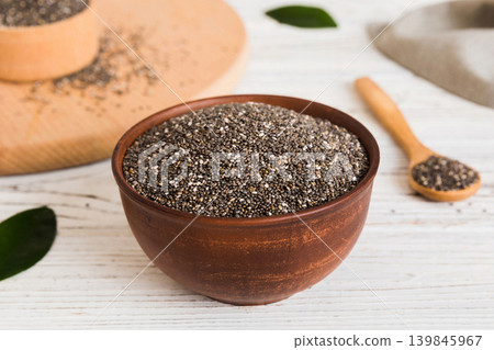 Chia seeds in bowl and spoon on colored background. Healthy Salvia hispanica in small bowl. Healthy superfood Chia seeds in bowl and spoon on colored background. Healthy Salvia hispanica in small bowl. Healthy superfood 139845967