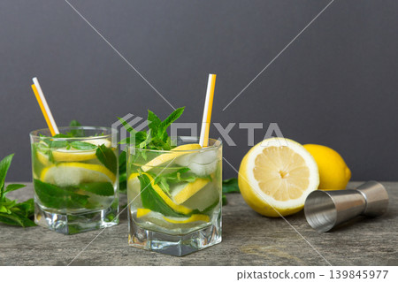 Mojito cocktail. Refreshing mojito cocktail with lime, lemon and mint in a tall glass with a stick Mojito cocktail. Refreshing mojito cocktail with lime, lemon and mint in a tall glass with a stick 139845977