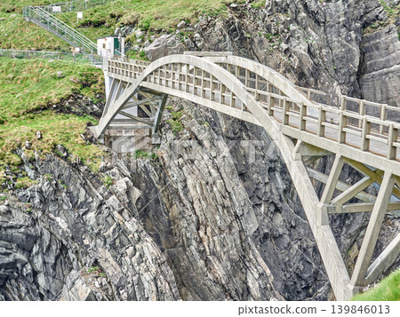 Concrete arch bridge crossing rocky coastal cliffs 139846013