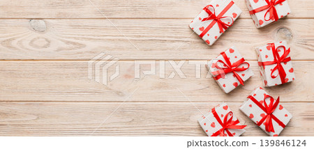 Valentine day composition: red gift box with bow and heart. Christmas present. View from above. Space for text. Holday greeting card Valentine day composition: red gift box with bow and heart. Christmas present. View from above. Space for text. Holday greeting card 139846124