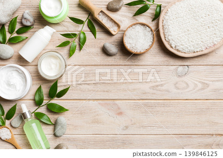 Coconut with jars of coconut oil and cosmetic cream on colored background. Top view. Free space for your text. Natural spa coconut cosmetics and organic treatment concept Coconut Spa composition Coconut with jars of coconut oil and cosmetic cream on colored background. Top view. Free space for your text. Natural spa coconut cosmetics and organic treatment concept Coconut Spa composition 139846125
