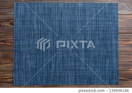 Top view of grey tablecloth for food on wooden background. Empty space for your design Top view of grey tablecloth for food on wooden background. Empty space for your design 139846186