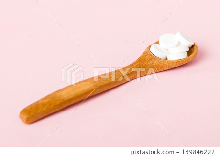 Heap of white pills on colored background. Tablets scattered on a table. Pile of red soft gelatin capsule. Vitamins and dietary supplements concept Heap of white pills on colored background. Tablets scattered on a table. Pile of red soft gelatin capsule. Vitamins and dietary supplements concept 139846222
