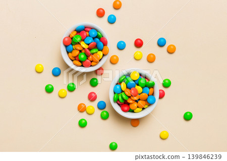 different colored round candy in bowl and jars. Top view of large variety sweets and candies with copy space different colored round candy in bowl and jars. Top view of large variety sweets and candies with copy space 139846239