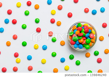 Multicolored candies in a bowl on a colored background. birthday and holiday concept. Top view with copy space 139846240