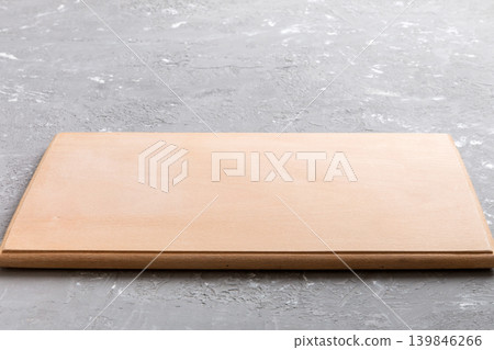 Perspective view of wooden cutting board on cement background. Empty space for your design Perspective view of wooden cutting board on cement background. Empty space for your design 139846266