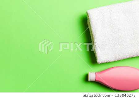 Cosmetic shampoo bottle mockup with towels on a colored table. Bathroom background, toilet accessories for hand and body care Cosmetic shampoo bottle mockup with towels on a colored table. Bathroom background, toilet accessories for hand and body care 139846272