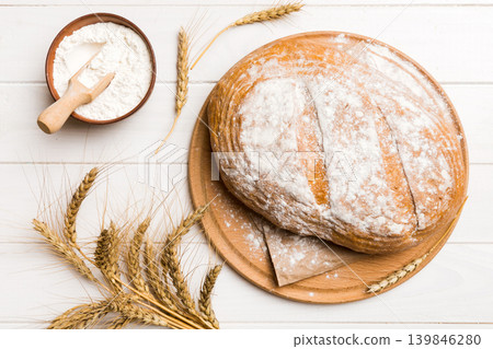 Freshly baked bread on cutting board against white wooden background. top view bread with copy space Freshly baked bread on cutting board against white wooden background. top view bread with copy space 139846280