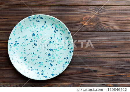 Top view of empty blue plate on wooden background. Empty space for your design Top view of empty blue plate on wooden background. Empty space for your design 139846312
