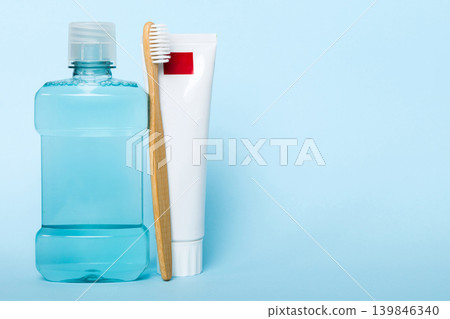 Mouthwash and other oral hygiene products on colored table top view with copy space. Flat lay. Dental hygiene. Oral care products and space for text on light background. concept Mouthwash and other oral hygiene products on colored table top view with copy space. Flat lay. Dental hygiene. Oral care products and space for text on light background. concept 139846340