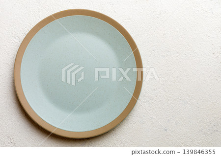Top view of empty light plate on cement background. Empty space for your design Top view of empty light plate on cement background. Empty space for your design 139846355