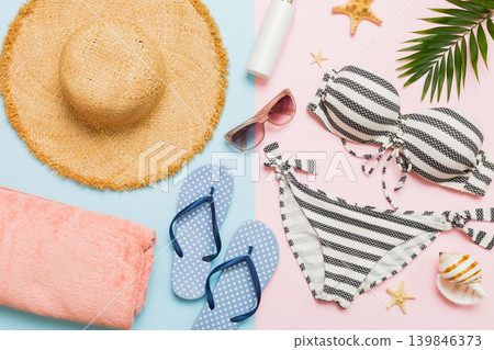 Woman swimwear and beach accessories flat lay top view. Top view with bikini outfit on color background. Vacation concept copy space Woman swimwear and beach accessories flat lay top view. Top view with bikini outfit on color background. Vacation concept copy space 139846373