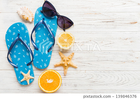Top view composition of flip flops placed with beach accessories top view on table background. Tropical summer vacation concept Flat lay Top view composition of flip flops placed with beach accessories top view on table background. Tropical summer vacation concept Flat lay 139846376