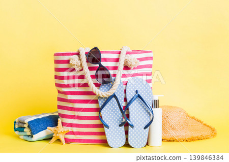 Stylish bag with beach accessories . Summer holiday concept. beach bag with straw hat with space for text Stylish bag with beach accessories . Summer holiday concept. beach bag with straw hat with space for text 139846384