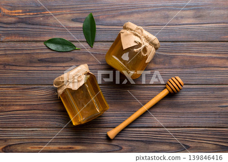 Honey jar with wooden honey dipper on white background top view with copy space. Delicious honey bottle Honey jar with wooden honey dipper on white background top view with copy space. Delicious honey bottle 139846416