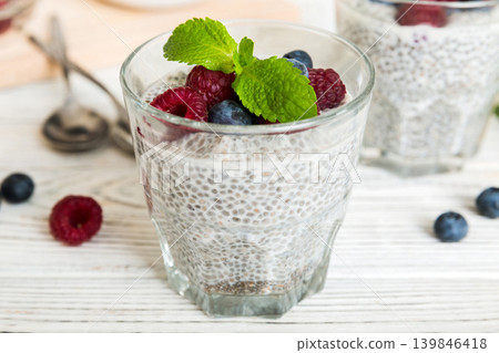 Healthy breakfast or morning with chia seeds vanilla pudding raspberry and blueberry berries on table background, vegetarian food, diet and health concept. Chia pudding with raspberry and blueberry Healthy breakfast or morning with chia seeds vanilla pudding raspberry and blueberry berries on table background, vegetarian food, diet and health concept. Chia pudding with raspberry and blueberry 139846418