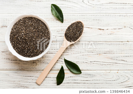 Chia seeds in bowl and spoon on colored background. Healthy Salvia hispanica in small bowl. Healthy superfood Chia seeds in bowl and spoon on colored background. Healthy Salvia hispanica in small bowl. Healthy superfood 139846434