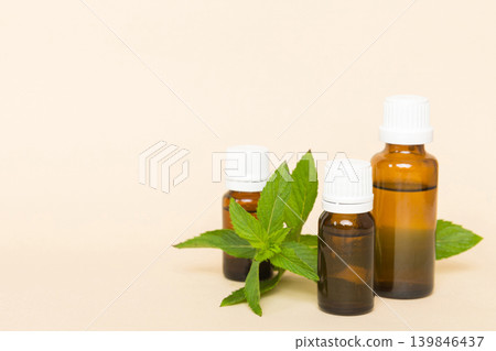 Natural Mint Essential Oil in a Glass Bottle. organic cosmetics with herbal extracts of mint on colored background 139846437