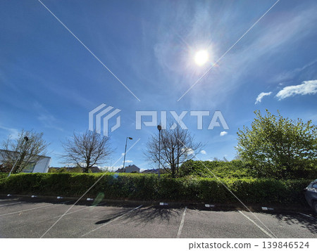 Clear Sky with Clouds Over Green Grass and Street Light by the Asphalt Road, Tree in Background, Sunlight Illuminating the Scene Clear Sky with Clouds Over Green Grass and Street Light by the Asphalt Road, Tree in Background, Sunlight Illuminating the Scene 139846524