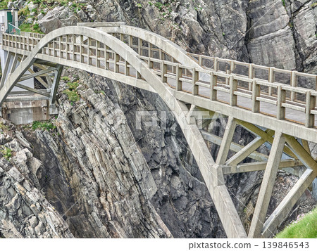 Concrete arch bridge crossing rocky mountain gorge 139846543