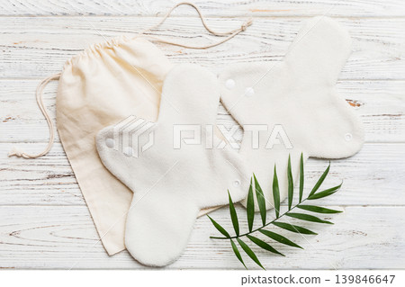 lean feminine sanitary napkin with green leaf. Absence of menstruation in woman. Minimal concept of female menopause. Copy space top view lean feminine sanitary napkin with green leaf. Absence of menstruation in woman. Minimal concept of female menopause. Copy space top view 139846647