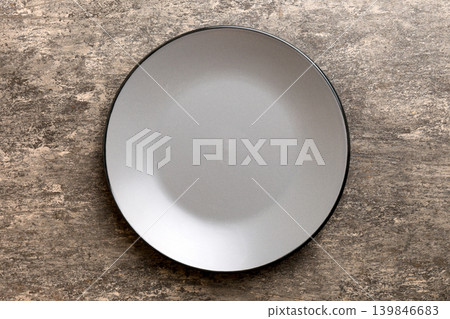 Top view of black plate on cement background. Empty space for your design Top view of black plate on cement background. Empty space for your design 139846683