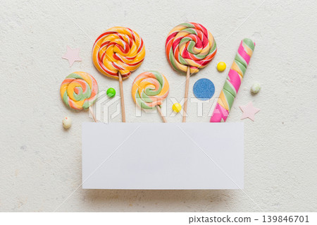 Flat lay holiday composition. Paper blank, lollipop, birthday decorations on Colored background. Top view, copy space for text Flat lay holiday composition. Paper blank, lollipop, birthday decorations on Colored background. Top view, copy space for text 139846701