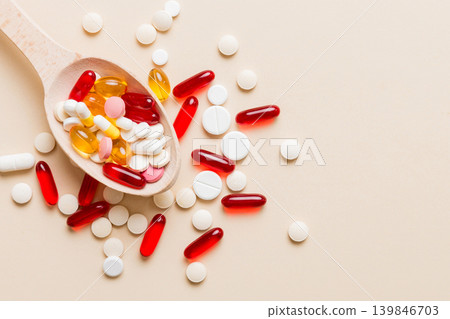 Vitamin capsules in a spoon on a colored background. Pills served as a healthy meal. Red soft gel vitamin supplement capsules on spoon Vitamin capsules in a spoon on a colored background. Pills served as a healthy meal. Red soft gel vitamin supplement capsules on spoon 139846703