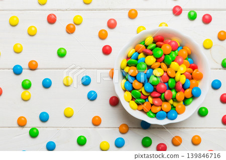 Multicolored candies in a bowl on a colored background. birthday and holiday concept. Top view with copy space Multicolored candies in a bowl on a colored background. birthday and holiday concept. Top view with copy space 139846716