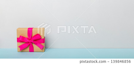 holiday paper present tied pink ribbon bow top view with copy space. Flat lay holiday background. Birthday or christmas present. Christmas gift box concept with copy space holiday paper present tied pink ribbon bow top view with copy space. Flat lay holiday background. Birthday or christmas present. Christmas gift box concept with copy space 139846856