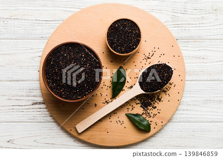 quinoa seeds in bowl and spoon on colored background. Healthy kinwa in small bowl. Healthy superfood quinoa seeds in bowl and spoon on colored background. Healthy kinwa in small bowl. Healthy superfood 139846859